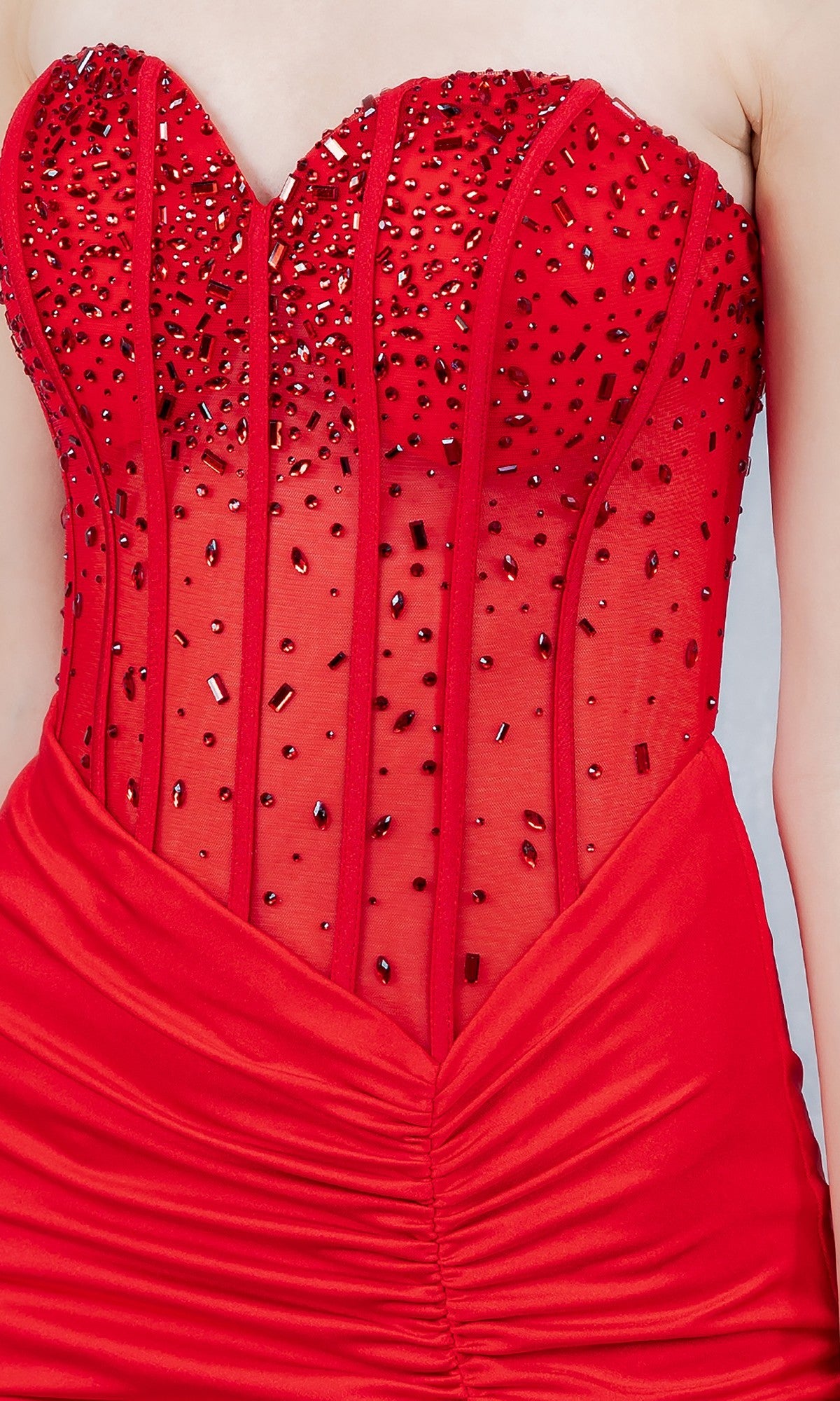 Someone wears the Cinderella Couture 8443J long prom dress in red, featuring a strapless, fitted jeweled corset bodice, ruched waist, and a dramatic thigh-high slit.